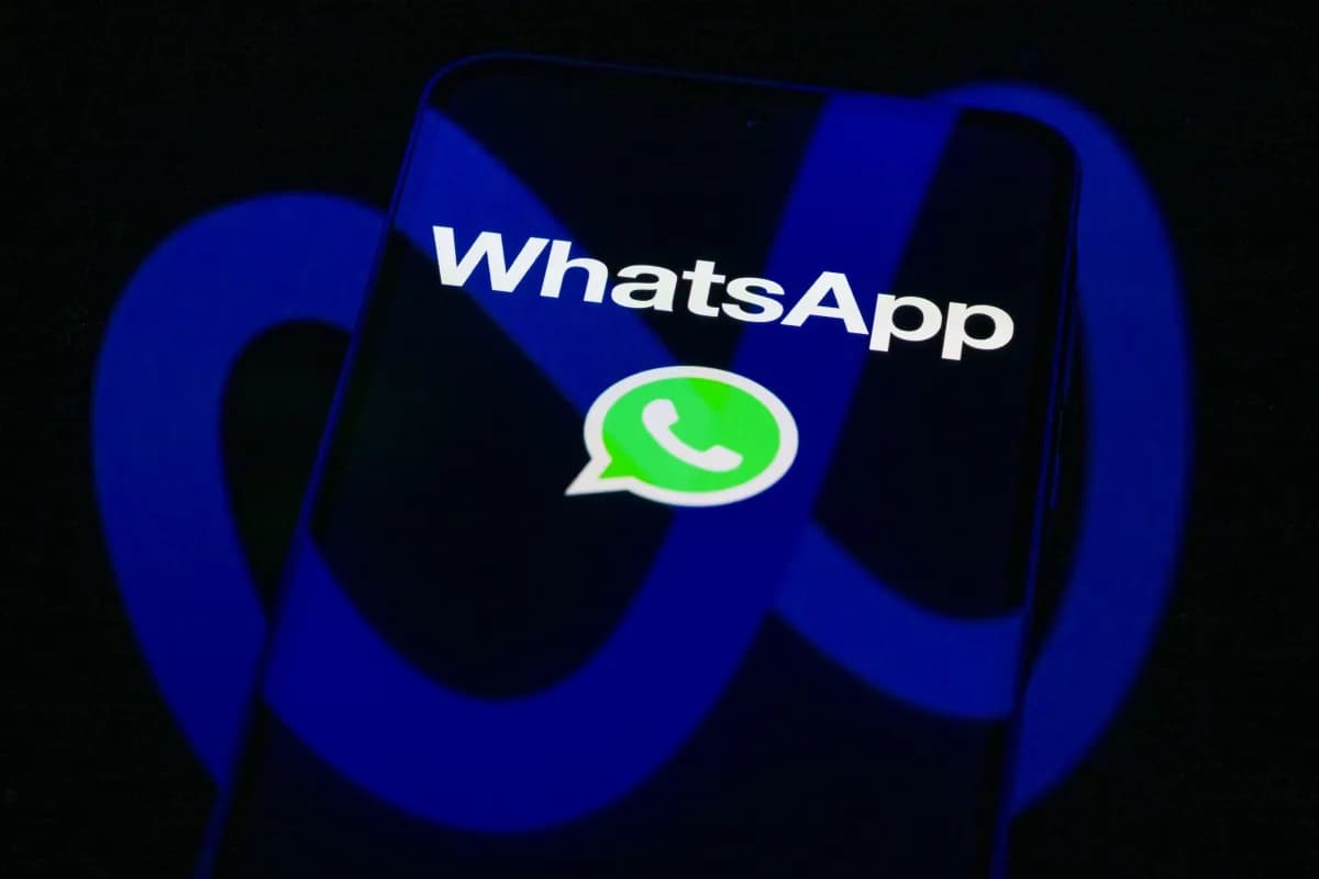 Teléfono celular con el logo de WhatsApp en pantalla sobre el símbolo de Meta