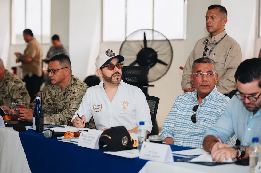 Reunión de un consejo de seguridad con funcionarios civiles y oficiales del Ejército sentados alrededor de una mesa larga