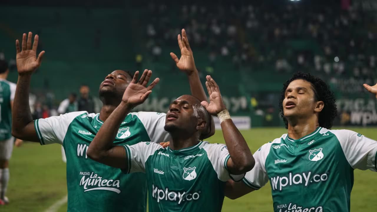 Jugadores del Deportivo Cali con los brazos en alto en un partido de la Liga BetPlay