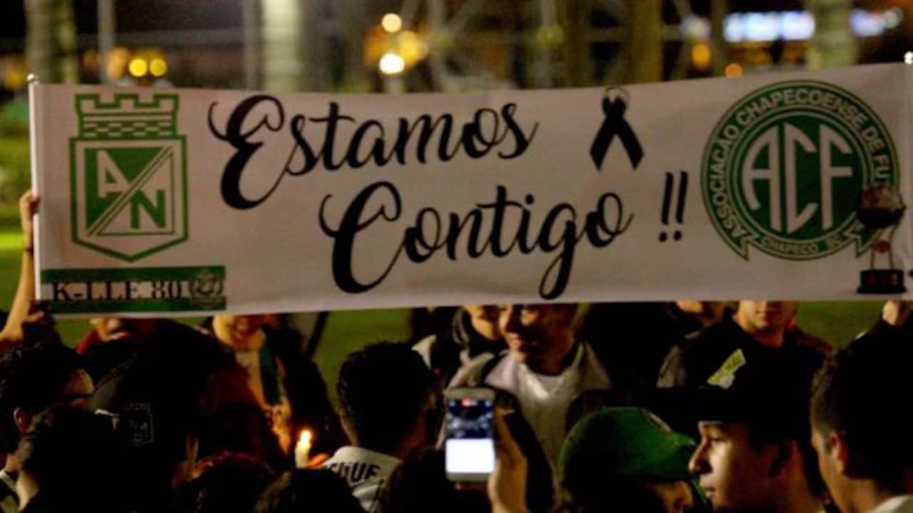 Hinchas de Atlético Nacional sostienen una pancarta de apoyo a Chapecoense durante el homenaje a las víctimas en 2016