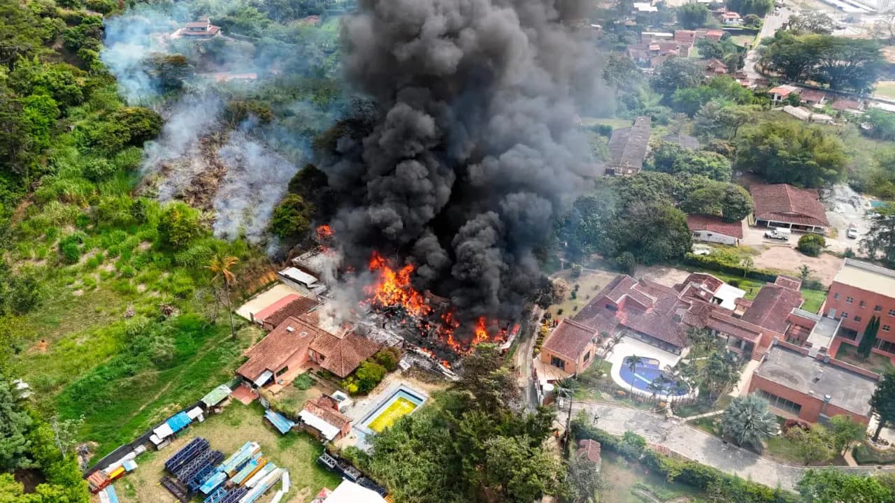 Vista aérea de una columna de humo negro sobre las bodegas incendiadas en una zona rural de Girardota
