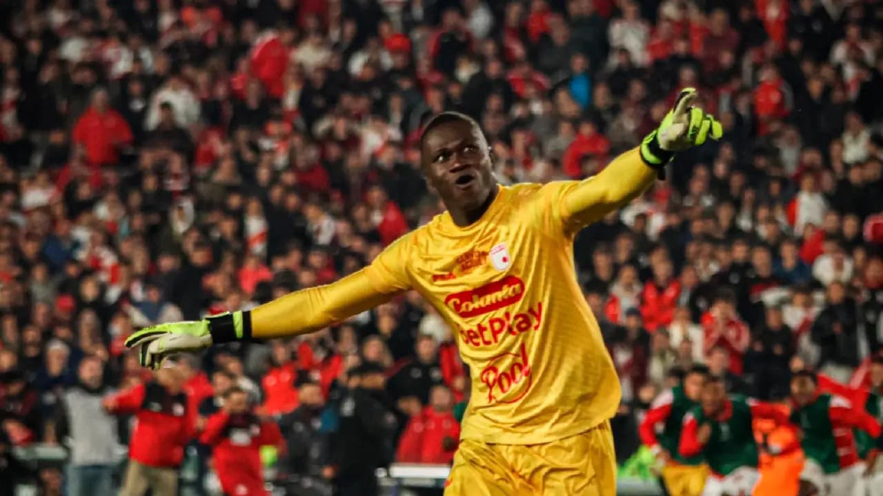 El arquero de Santa Fe, de uniforme amarillo, celebra con los brazos abiertos frente a una tribuna llena