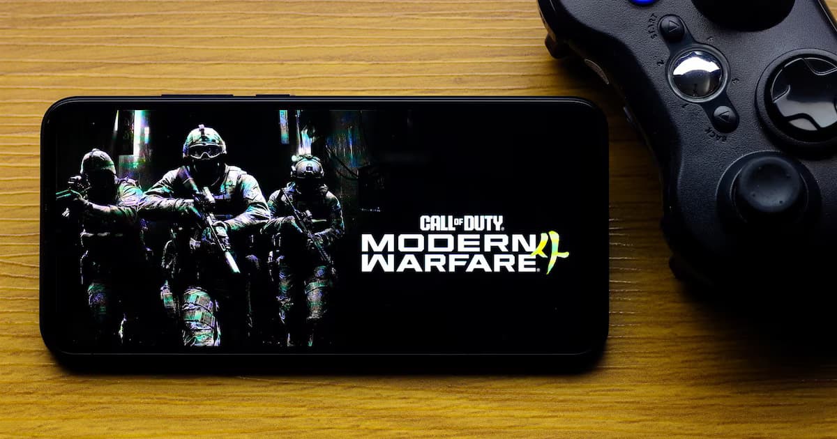 Un celular muestra la portada de Call of Duty: Modern Warfare 4 junto a un control de videojuegos