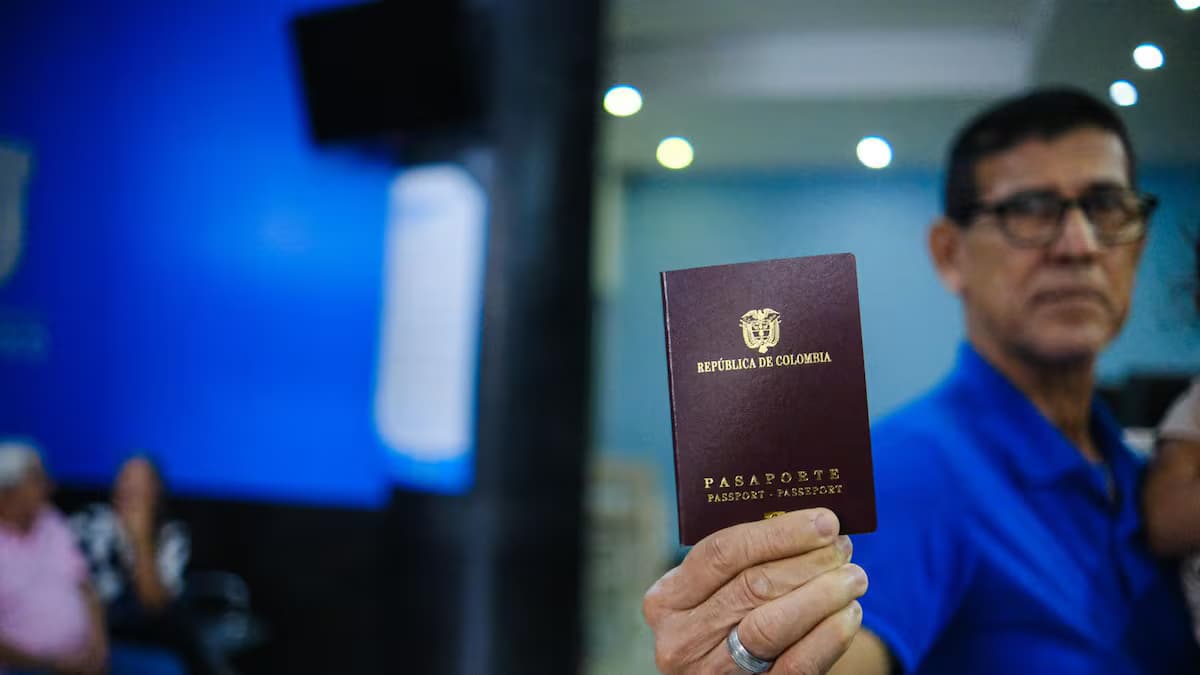 Un ciudadano sostiene su pasaporte colombiano en una oficina de expedición