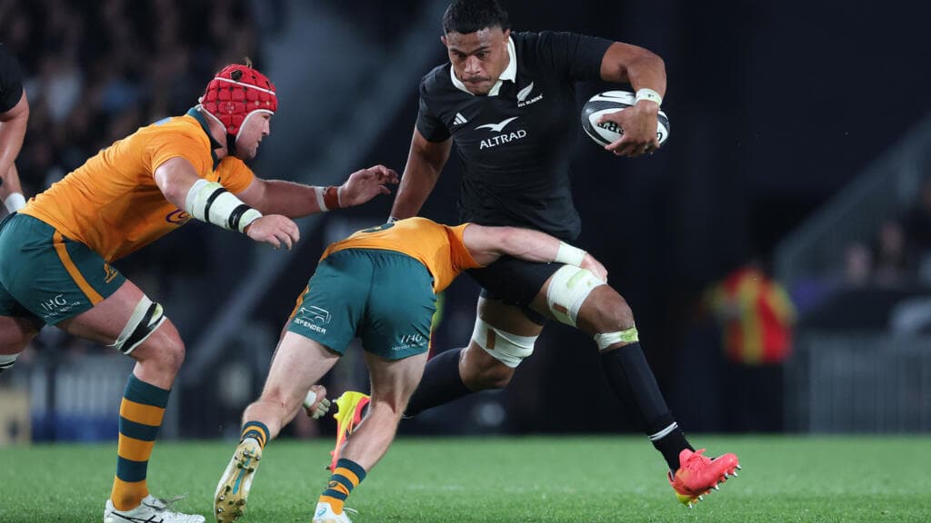 Un jugador de los All Blacks carga el balón ante la marca de dos jugadores australianos en Eden Park