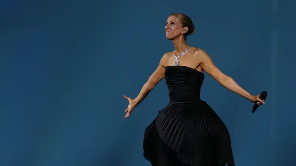 Céline Dion, con vestido negro, abre los brazos en el escenario durante uno de sus conciertos en París