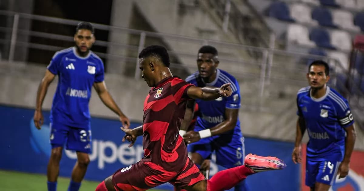 Un jugador de Barranquilla FC remata ante la marca de futbolistas de Millonarios en el estadio Romelio Martínez