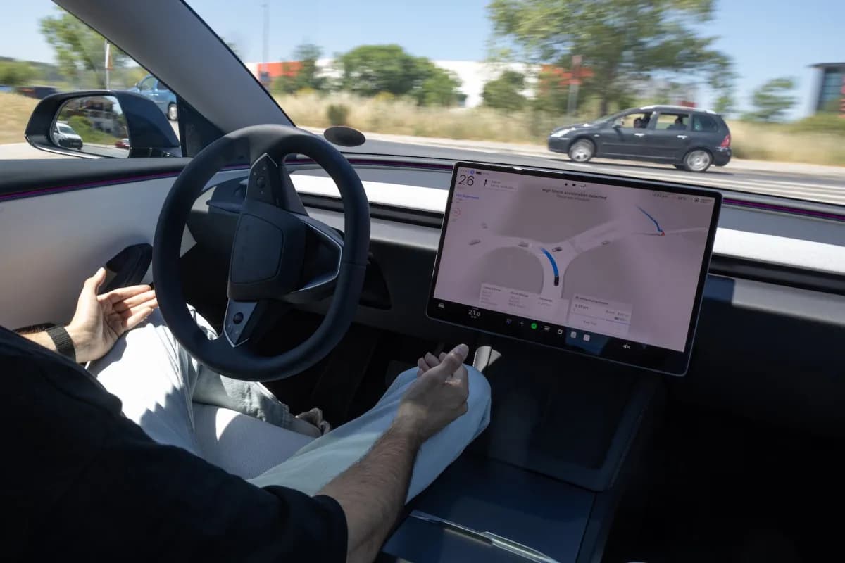 Un conductor con las manos fuera del volante de un Tesla mientras opera el sistema de asistencia