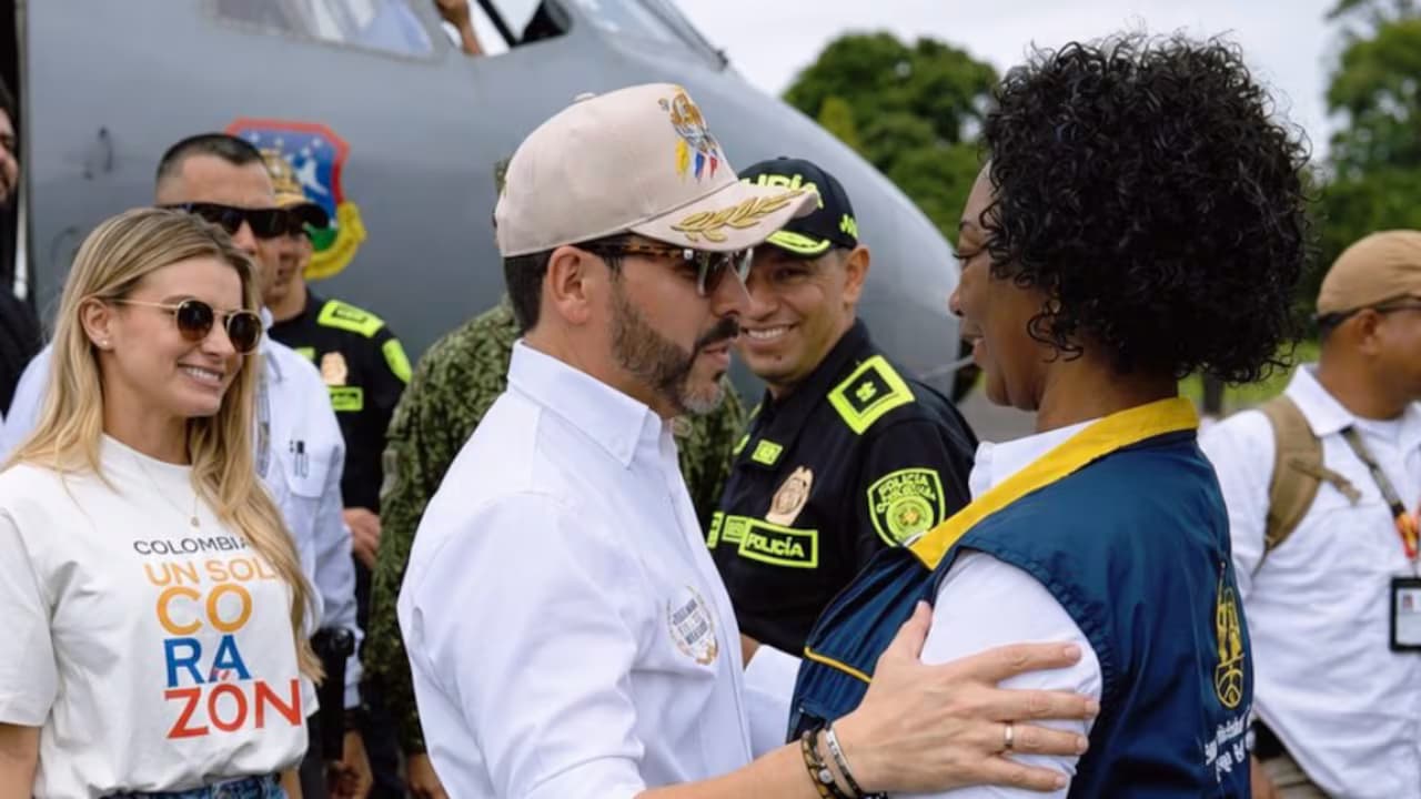 El presidente Abelardo de la Espriella saluda a una mujer damnificada frente a un avión militar durante una visita al Pacífico