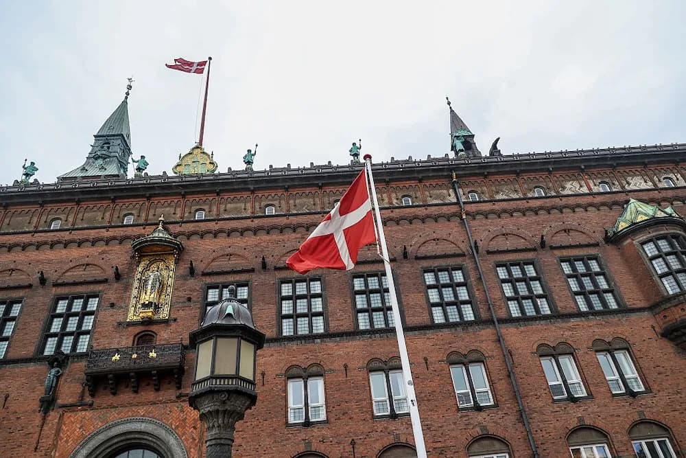 Bandera de Dinamarca ondea frente al edificio del Ayuntamiento de Copenhague