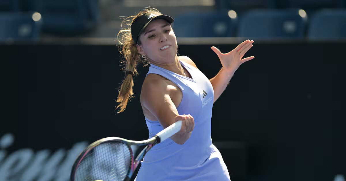 Camila Osorio golpea una derecha con la mano izquierda extendida, vestida de blanco y con visera oscura, en una cancha de tenis