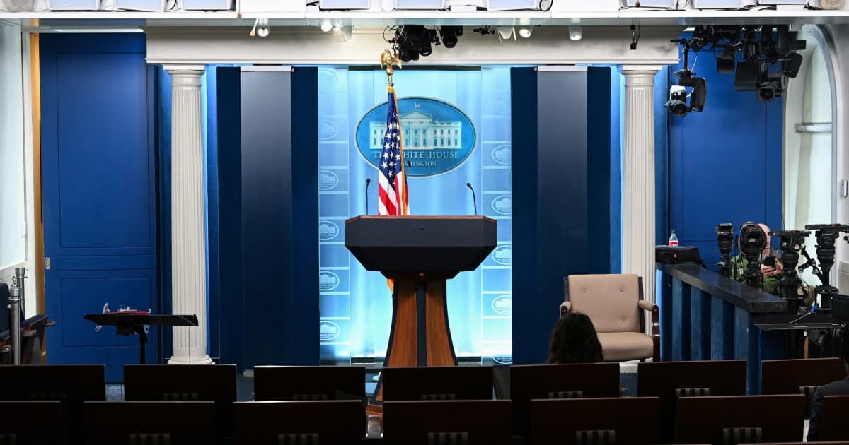 Sala de prensa de la Casa Blanca con el atril vacío y cámaras de televisión al fondo