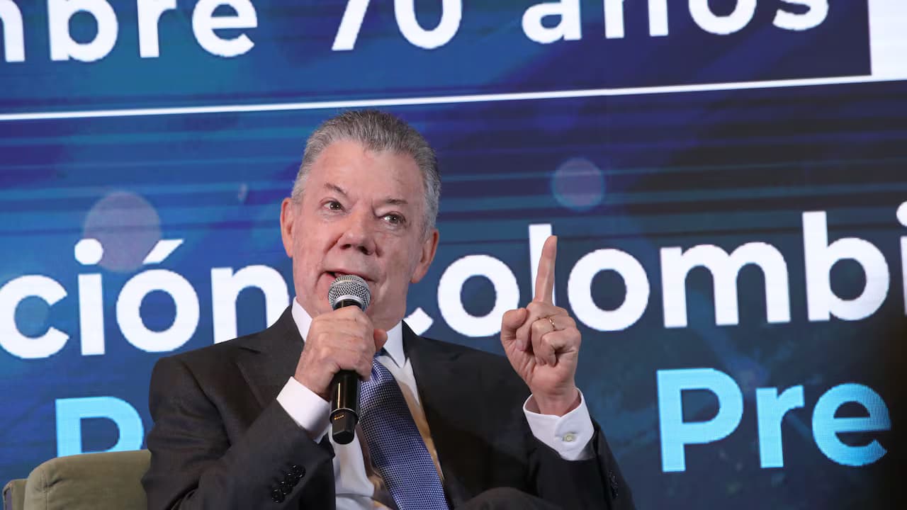 El expresidente Juan Manuel Santos habla con un micrófono durante un foro