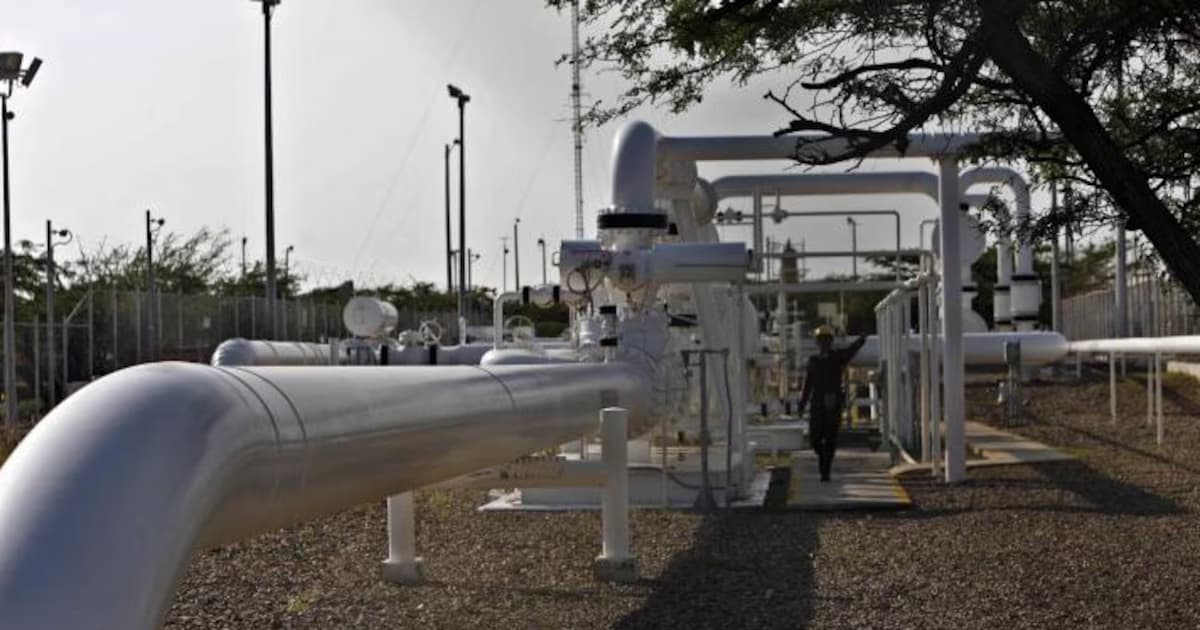 Tuberías de una estación de gas con un operario al fondo