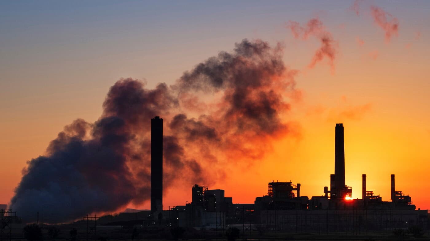 Chimeneas de una central térmica de carbón expulsan humo contra el sol del amanecer