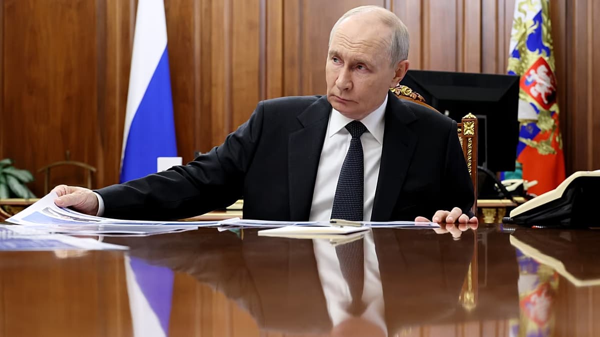 Vladimir Putin, sentado a una mesa de madera con documentos, en su despacho del Kremlin