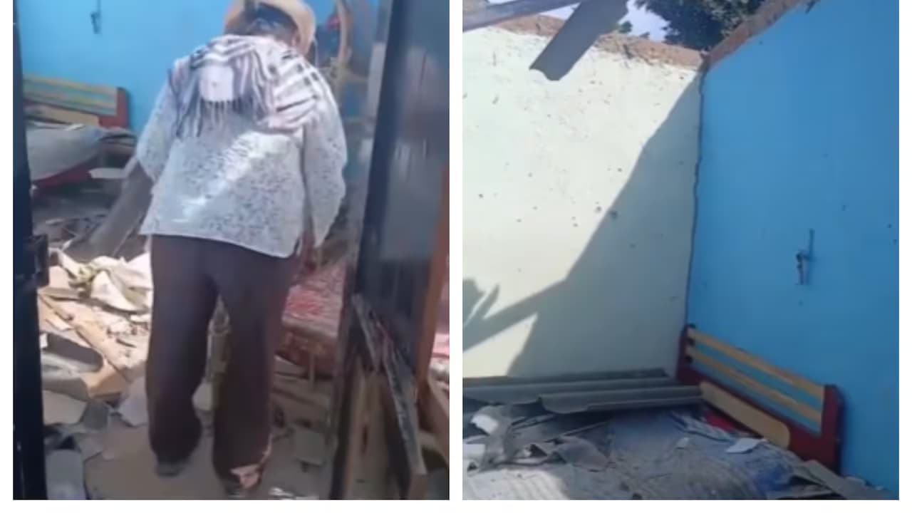 Una adulta mayor camina entre los escombros de su casa destruida por un dron en la vereda Tabiles, en Linares, Nariño