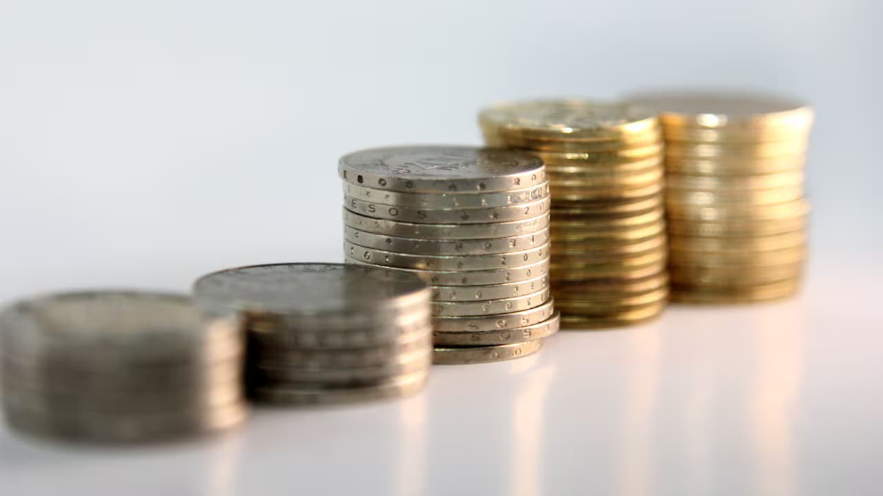Pilas de monedas colombianas de distintas denominaciones