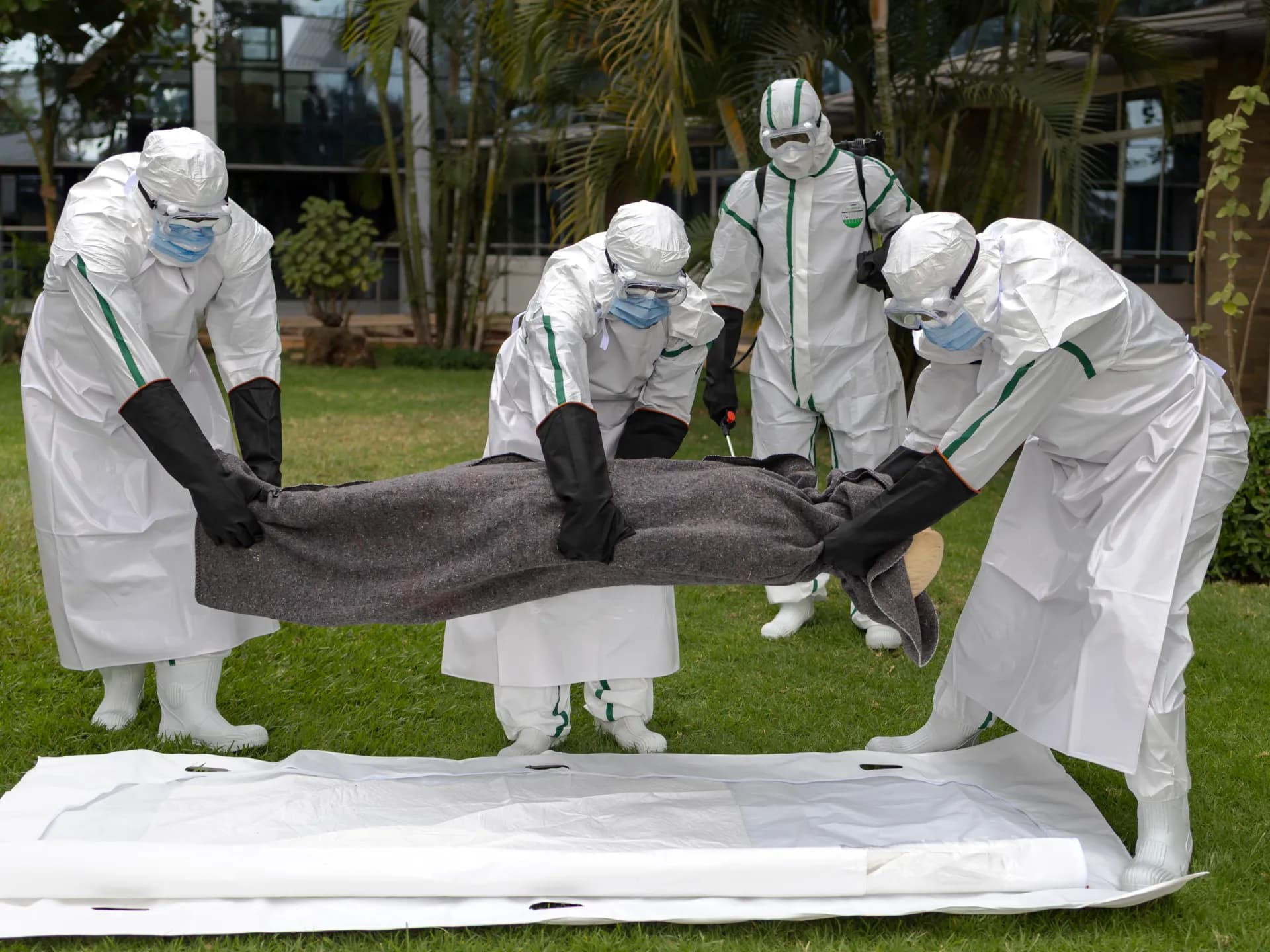 Voluntarios con trajes de protección hacen un simulacro de manejo de un cuerpo durante un entrenamiento contra el ébola en Kenia