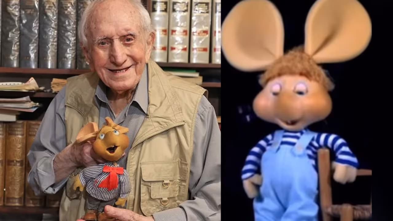 Peppino Mazzullo sostiene un muñeco de Topo Gigio junto a una imagen del personaje