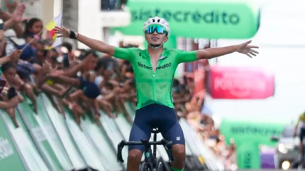 Estiven García, con el uniforme verde del Team Sistecrédito, levanta los brazos al cruzar la meta en Anserma