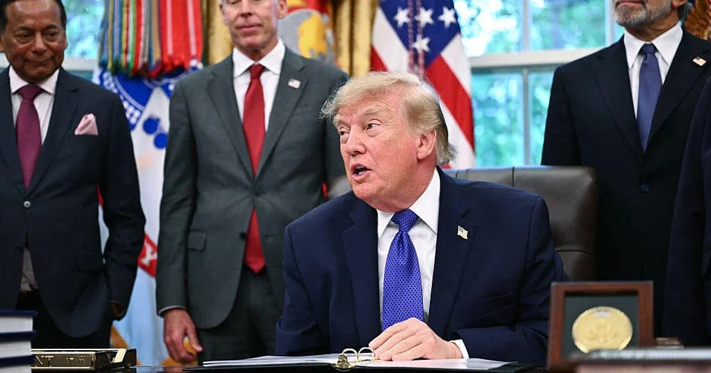 Donald Trump habla sentado en el escritorio de la Oficina Oval, rodeado de ejecutivos y funcionarios