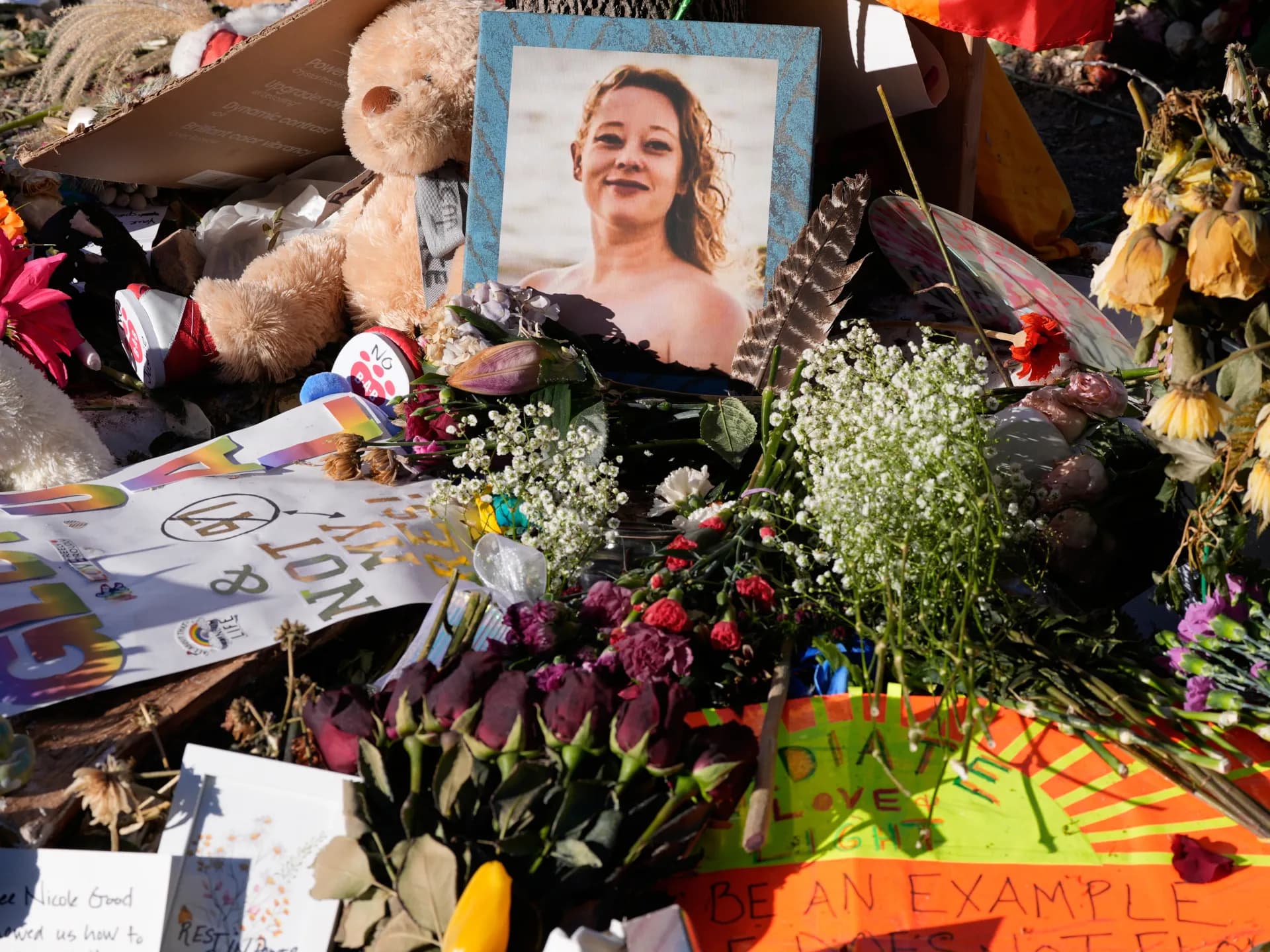 Retrato de Renee Good rodeado de flores, peluches y mensajes en un memorial en Minneapolis
