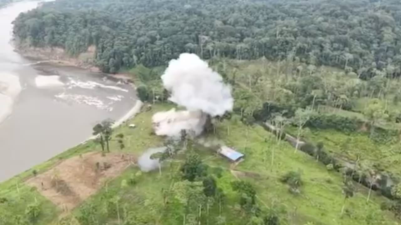 Vista aérea de una explosión en una zona selvática junto a un río durante una operación militar