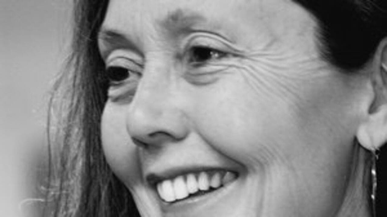 Retrato en blanco y negro de la escritora canadiense Anne Carson, sonriente