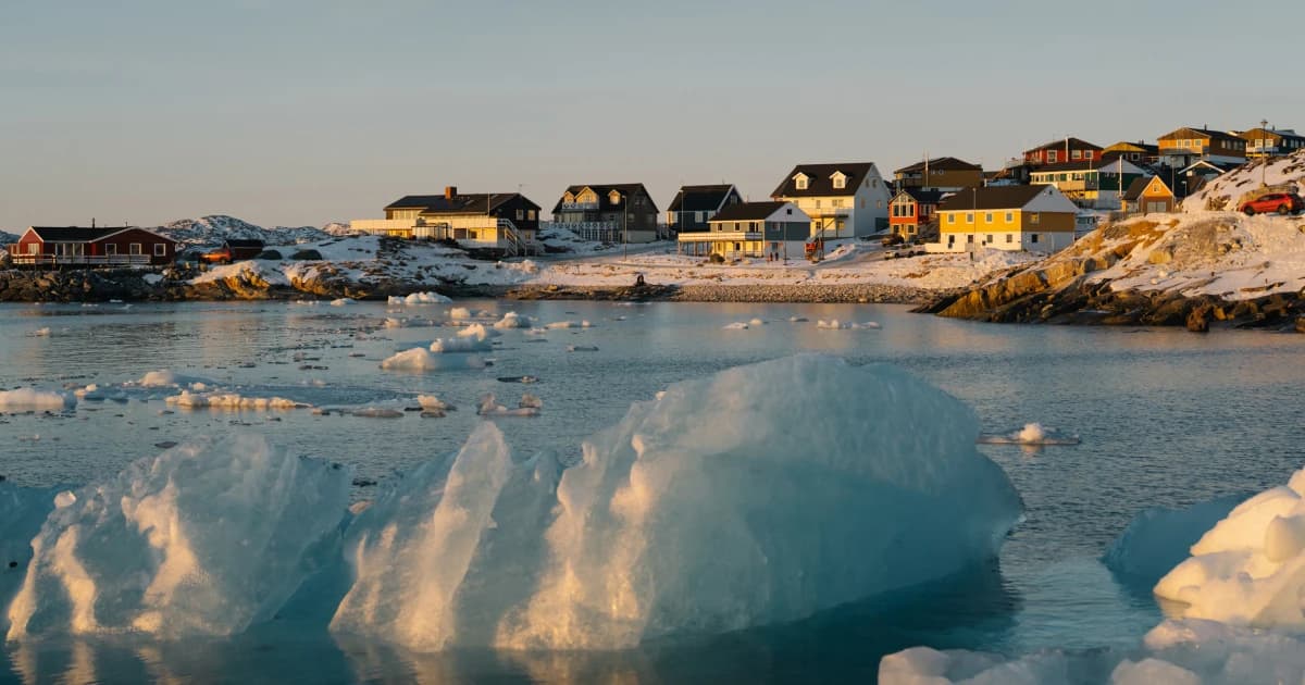 Casas de colores junto a un fiordo con témpanos de hielo en Groenlandia