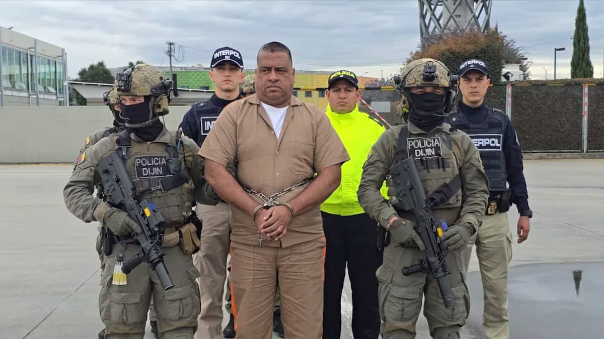Alias Araña, esposado y con uniforme de detenido, custodiado por agentes de la Dijín y de Interpol antes de su extradición