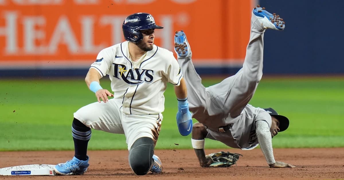 Un jugador de los Rays llega a segunda base mientras un defensor de los Yankees cae tras la jugada