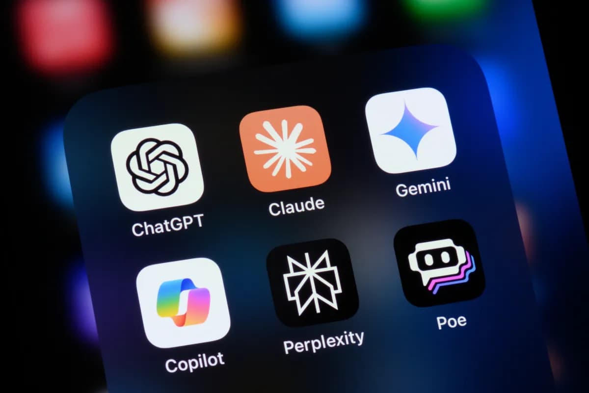 Primer plano de la pantalla de un teléfono con los iconos de las aplicaciones ChatGPT, Claude, Gemini, Copilot, Perplexity y Poe agrupados en una carpeta