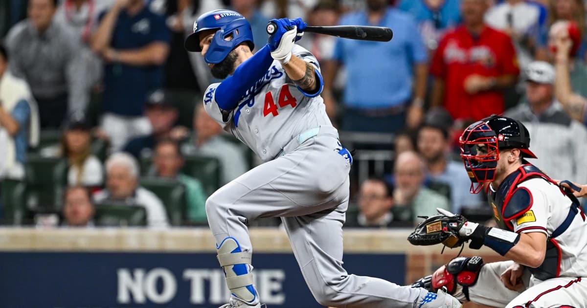 Andy Pages, de los Dodgers, conecta un batazo ante el receptor de los Bravos en Atlanta