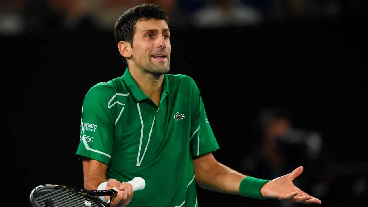 Novak Djokovic abre los brazos con la raqueta en la mano durante un partido
