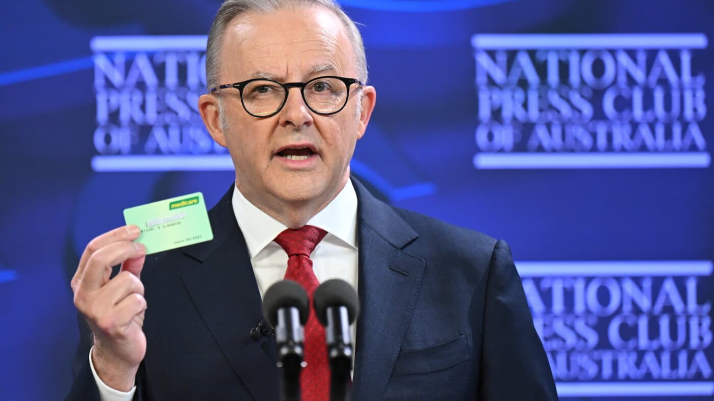El primer ministro de Australia, Anthony Albanese, muestra una tarjeta de Medicare durante una intervención en Canberra