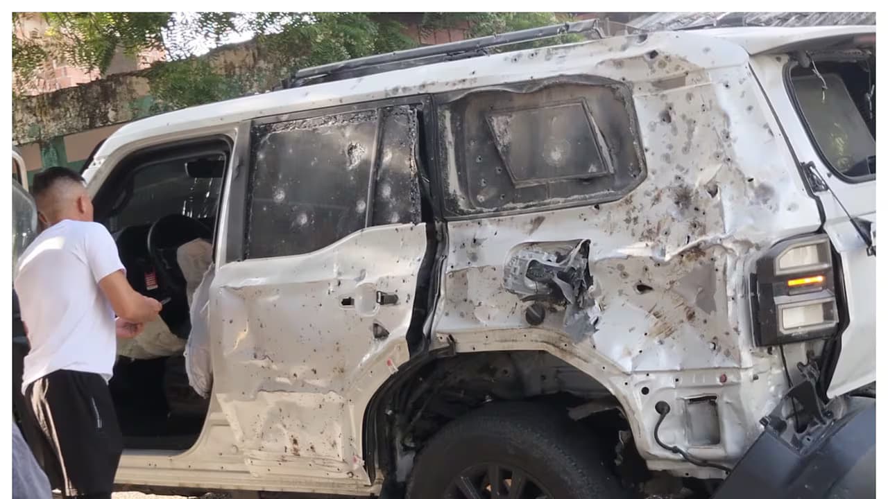 Una camioneta blanca con impactos de metralla y bala tras un ataque