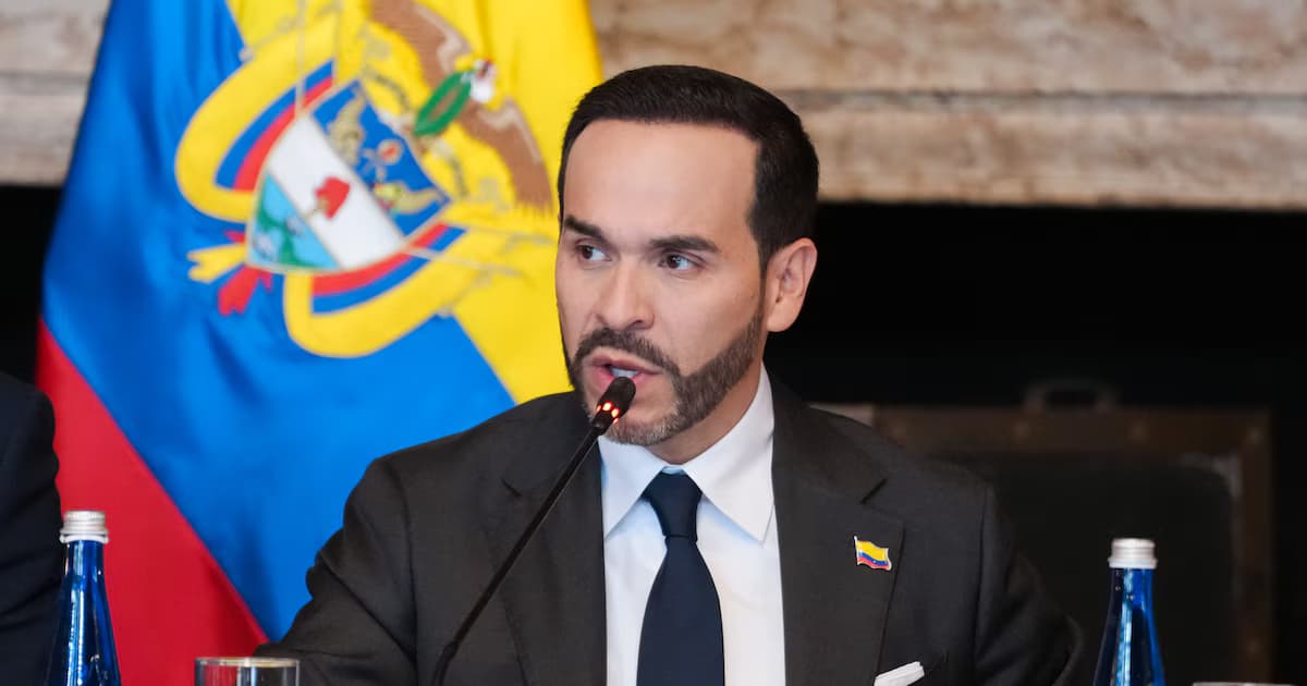 El presidente Abelardo De La Espriella habla ante un micrófono de mesa, con la bandera de Colombia detrás y botellas de agua sobre el escritorio