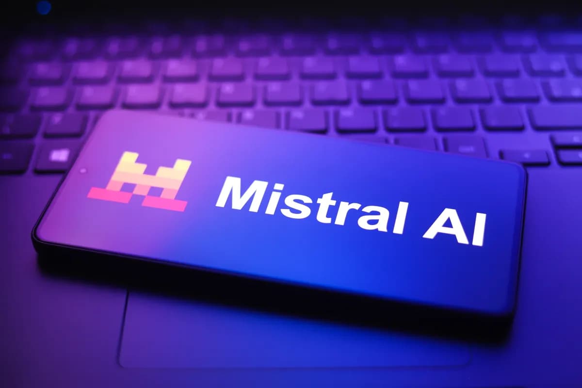 Un teléfono móvil con el logo de Mistral AI sobre el teclado de un computador portátil
