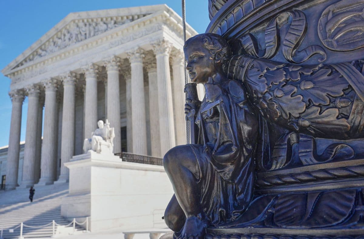 Fachada de la Corte Suprema de Estados Unidos, en Washington, con una escultura de bronce en primer plano
