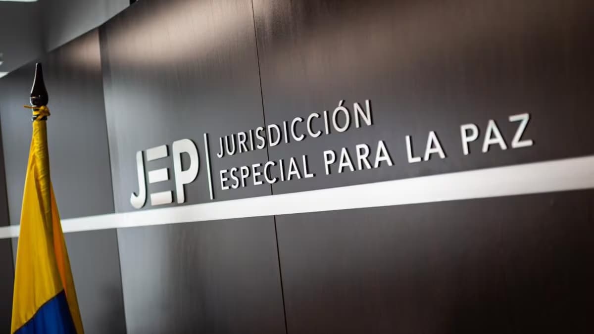 Letrero de la Jurisdicción Especial para la Paz junto a la bandera de Colombia en la sede del tribunal