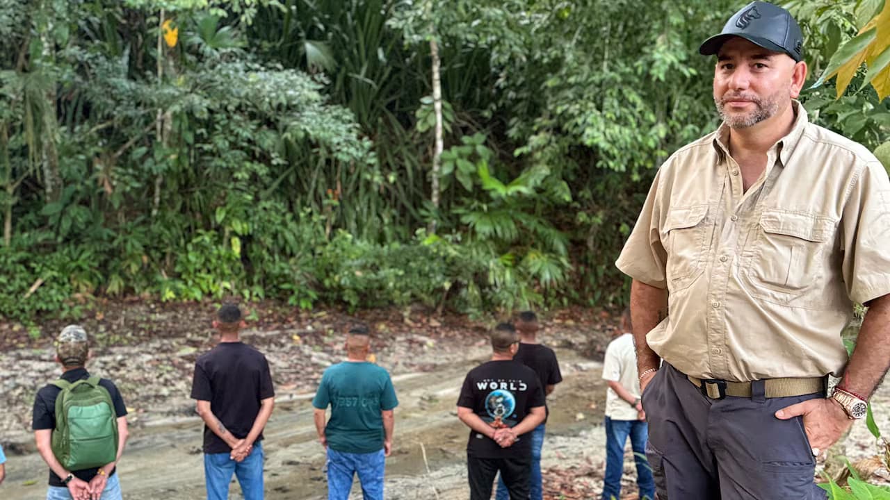 Fredy Castillo Carrillo, alias Pinocho, con gorra negra y camisa caqui en un claro de selva, con varios hombres de espaldas detrás