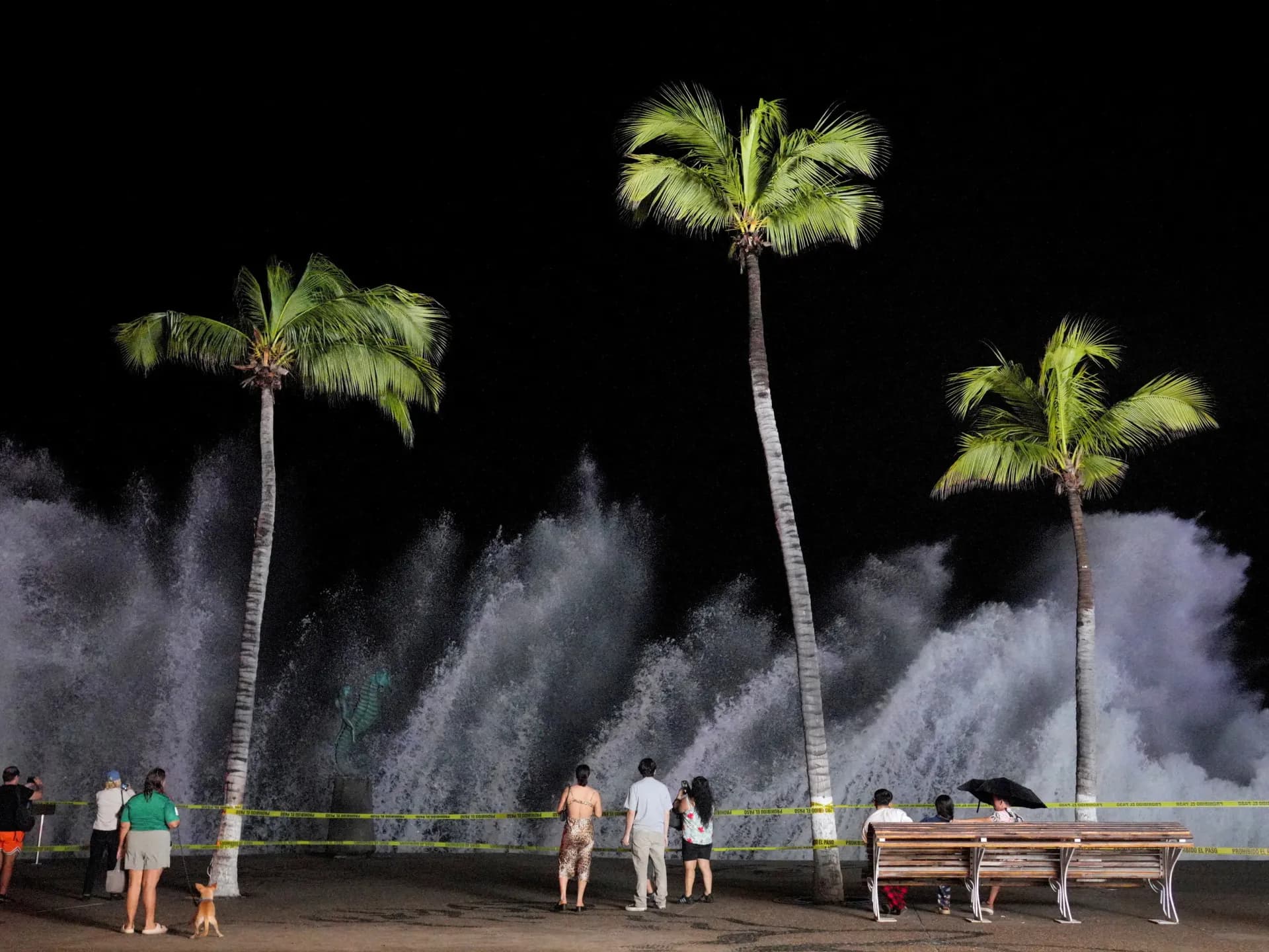 Personas observan las olas que golpean el malecón de Puerto Vallarta por el paso del huracán Simón