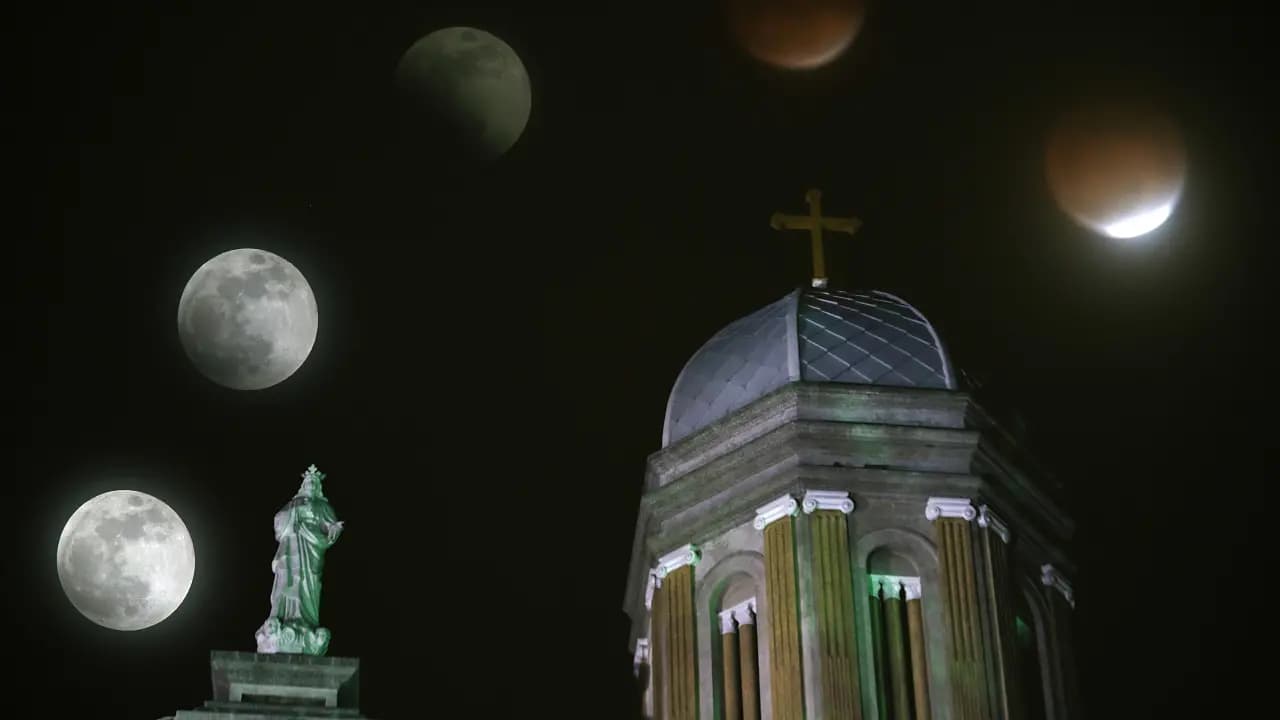Varias fases de un eclipse lunar sobre las torres de una iglesia en la noche