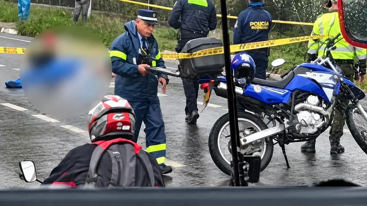 Agentes de tránsito y policías acordonan bajo la lluvia el lugar del siniestro en la autopista Medellín-Bogotá