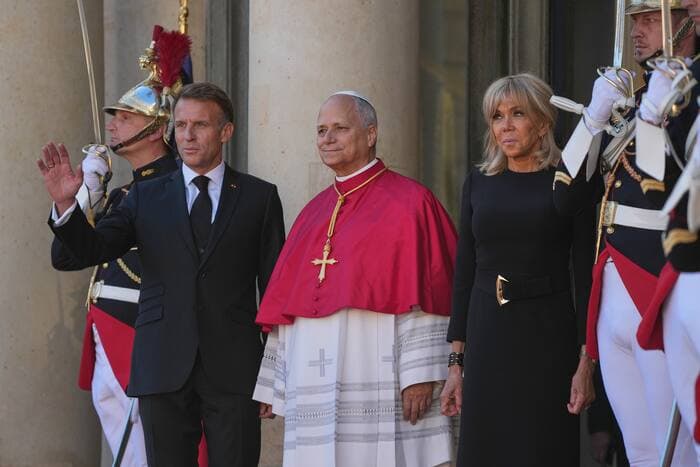 El papa León XIV, en el centro, es recibido por el presidente Emmanuel Macron y su esposa, Brigitte, a su llegada al palacio del Elíseo