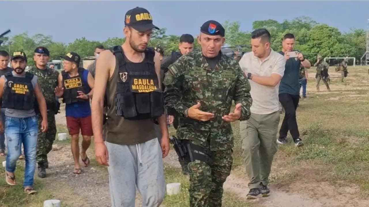 Personas rescatadas caminan con chalecos del Gaula Magdalena Medio junto a un oficial del Ejército