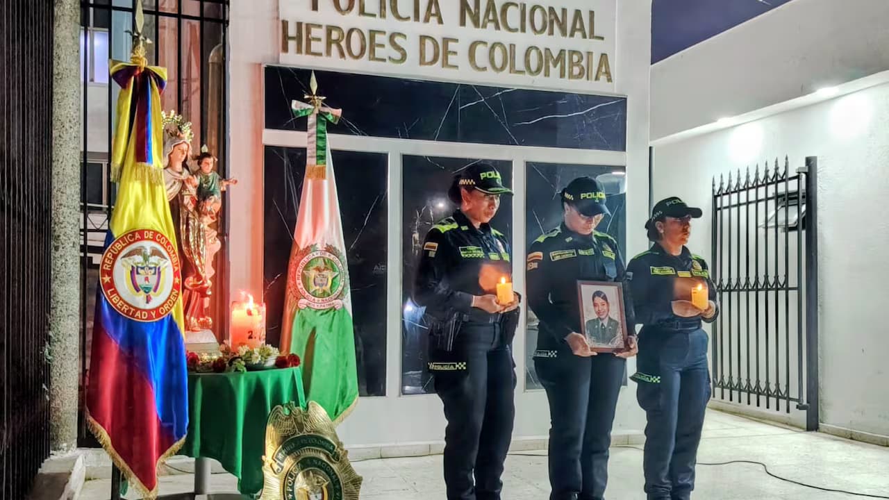 Policías con velas y un retrato de la patrullera María José Recuero Suárez durante una velatón en Cali