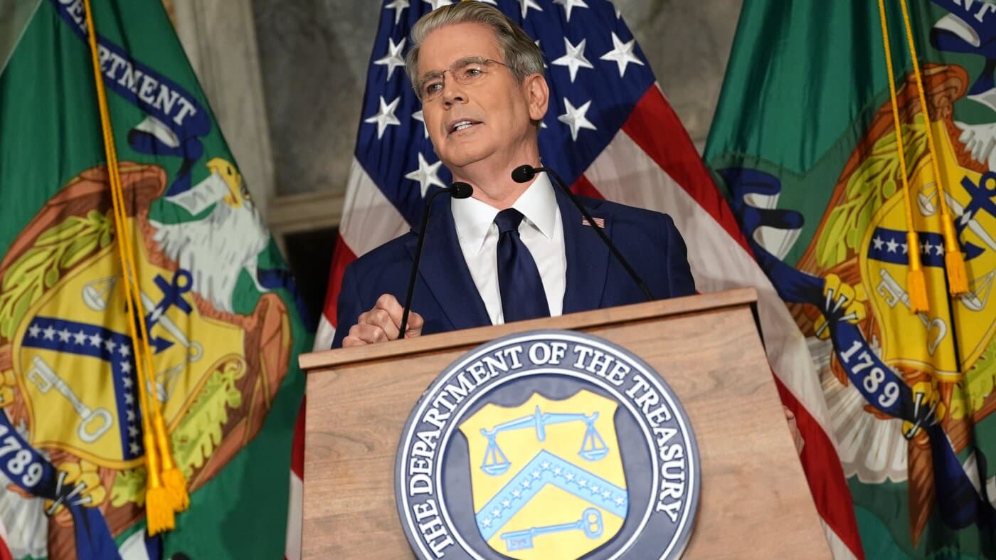 El secretario del Tesoro de Estados Unidos habla en un atril con el sello del Departamento del Tesoro y banderas al fondo