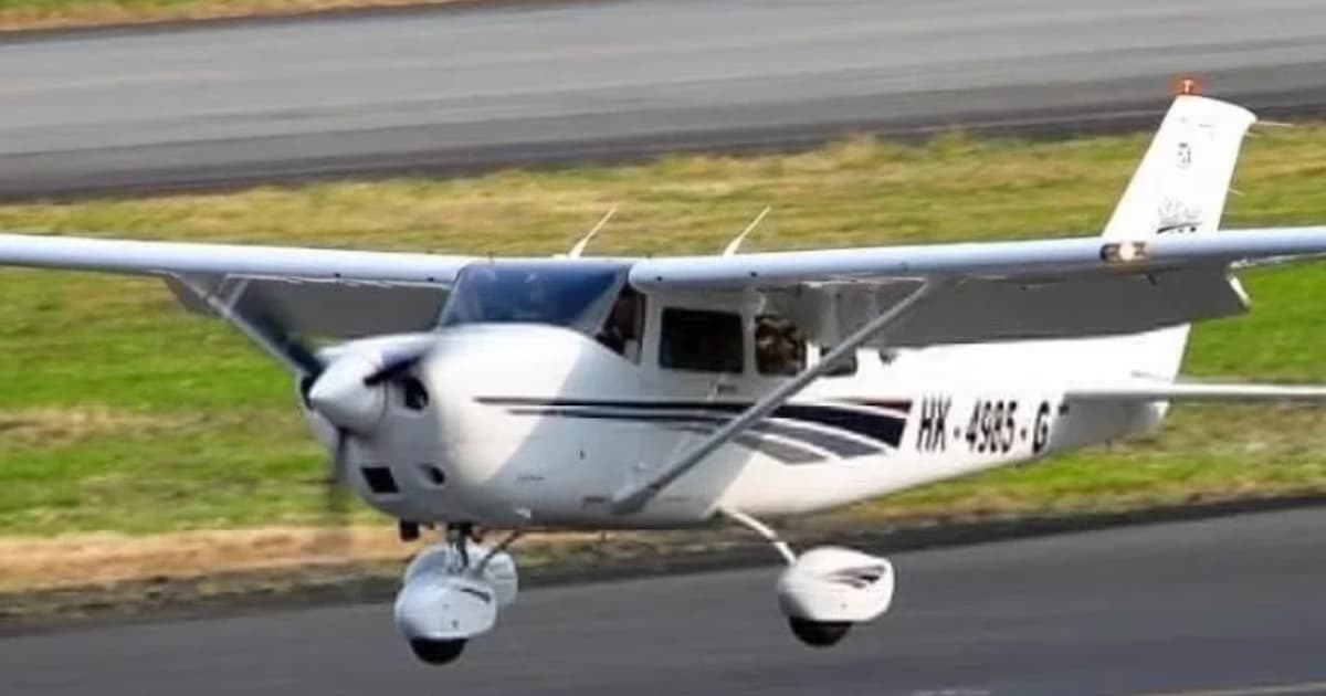 Avioneta Cessna blanca de matrícula HK-4985-G en vuelo bajo sobre una pista